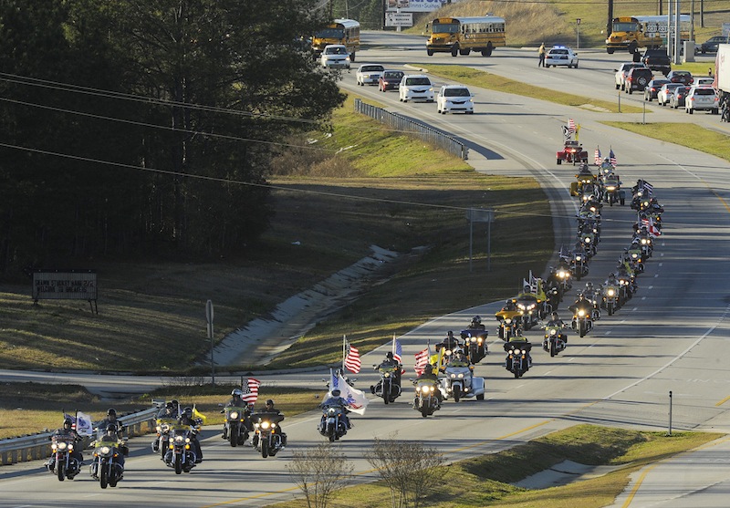 The funeral procession of slain bus driver Charles "Chuck" Poland makes its way down Highway 231 in Ozark, Ala., Sunday Over 60 motorcycles and dozens of school buses join the funeral procession. The Ozark Civic Center was packed with mourners for the funeral. Burial for Poland is in Newton, Ala. (AP Photo/AL.com, Joe Songer) MIDLAND CITY HOSTAGE CRISIS 2-3-2013