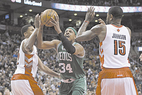 HERE I COME: Boston’s Paul Pierce, center, drives to the basket as Toronto’s Amir Johnson, right, and Rudy Gay defend during first-half action Wednesday in Toronto.