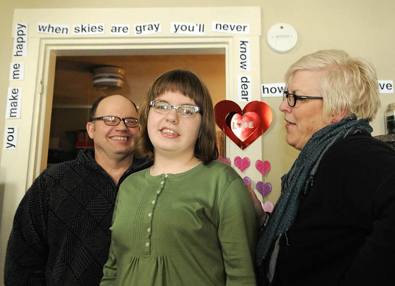 From left, Kevin, Addie and Heidi Bowden in their home on Friday. The Bowden family, Kevin, left, Addie and Heidi stand in their Augusta home underneath Valentine's Day decorations Heidi made for her daughter Addie,