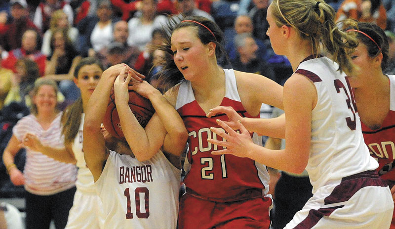 Bangor's Denae Johnson, left, battles for the ball with Cony's Alyssah Dennett, center, during the Eastern Class A championship game Friday at the Augusta Civic Center. Bangor derailed Cony's bid for a second straight regional title, winning 57-43.