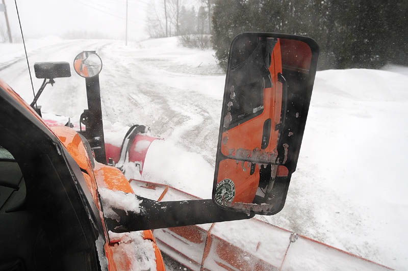 Snow flies of the plows of the truck driven by Augusta Public Works plow truck driver Stan Moore on Saturday.
