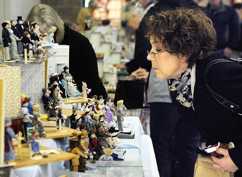 Judy DeGrandpre, of Freeport, looks at porcelain figures made by Elaine Perkins, of Our Dolls in Concord Township, on Saturday, during the Whitefield Lions Club Model Railroad & Doll House Show at the Augusta armory. DeGrandpre said that she had many of figurines made by Perkins.