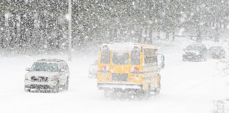 Cars drive in on Pierce Drive as buses leave Cony High School at 10:45 a.m. on Friday. Students were released early for the winter storm in Augusta.