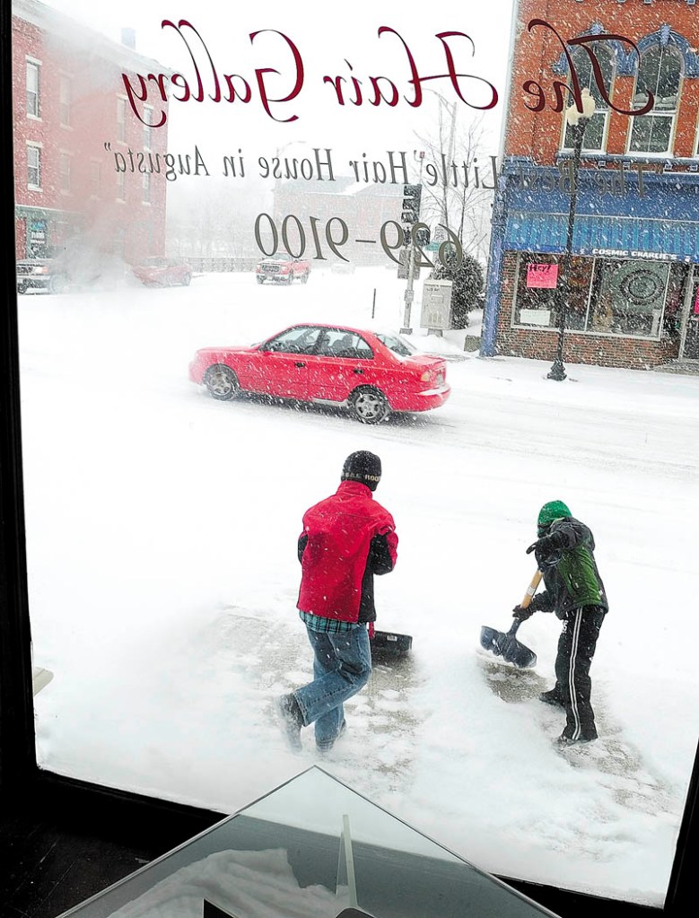 Staff photo by Joe Phelan Quincy Tobias, left, 9, and Sam Crilly, 6, shovel snow in front of The Hair Gallery, where both their mothers work, on Water Street in downtown Augusta on Friday February 8, 2013 during the winter storm in downtown Augusta.