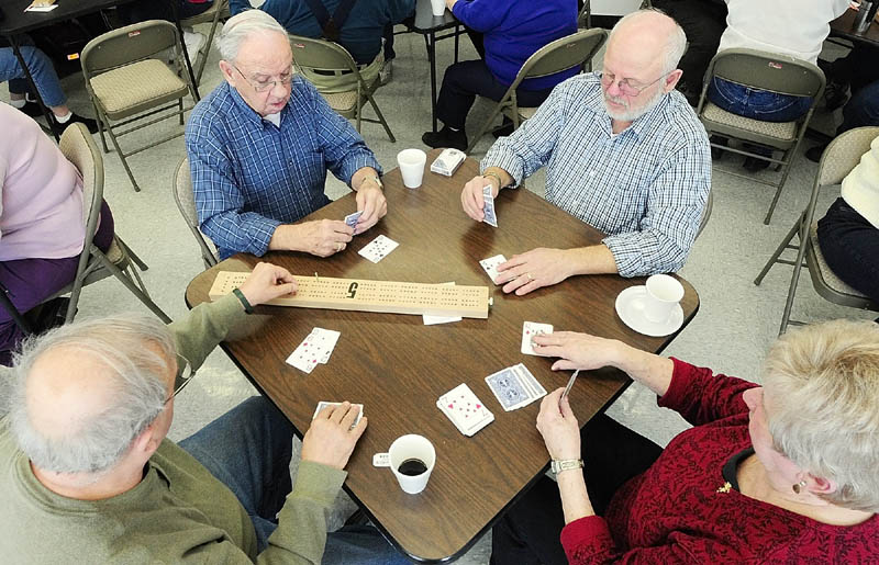 Roland Nault, left, moves a peg while playing cribbage with Lou Turmelle, Peter Bernier and Lorette Beland on Tuesday at the Buker Center in Augusta. There is a weekly cribbage session for seniors there every Tuesday from noon to 3 p.m.