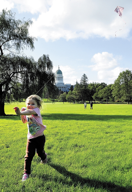 A child runs pulling a kite in October 2011 across Augusta's Capitol Park. Rep. Craig Hickman, D-Winthrop, has sponsored a bill to require that edible landscaping be placed in a portion of Capitol Park.