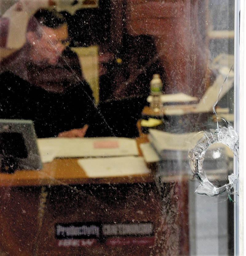 A hole from a BB gun is seen in one of five windows damaged at the International Brotherhood of Electrical Workers Local 1253 office in Fairfield, as Training Director Christopher Trider works inside on Monday.