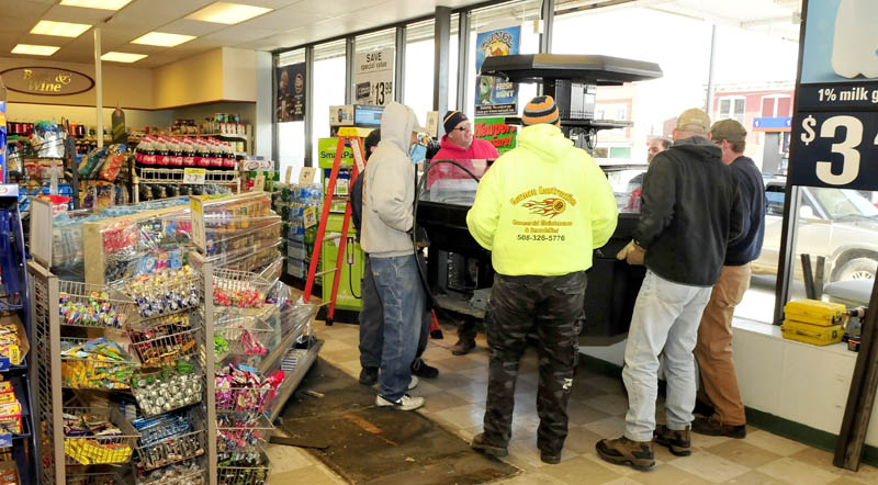Workers with Gorman Construction carry a food case through the storefront windows which were removed at Cumberland Farms in Fairfield, on Monday. The store is expanding and offering a larger coffee and sandwich counter.