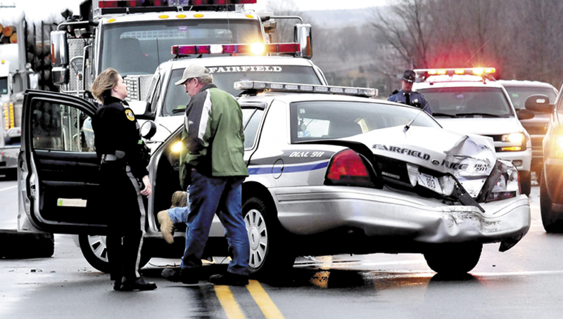 Fairfield police officer Shana Blodgett and Det. Sgt. Kingston Paul confer outside the cruiser that was destroyed, injuring officer Bill Beaulieu after the cruiser and a tractor trailer truck collided on U.S. Route 201 in Fairfield on Thursday, Jan. 31. The roadway was closed for hours as police from several departments investigated the accident.