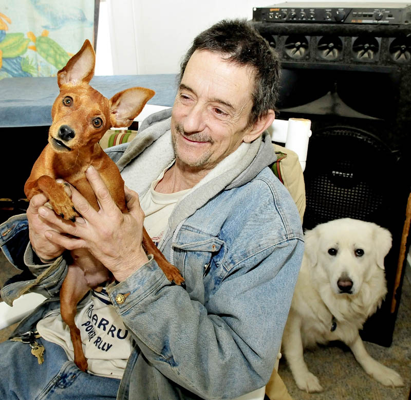 Gary Prentiss holds his dog, Ginger, as Angel sits behind him, at his home in Waterville on Feb. 4. Prentiss said Ginger is recovering after being struck by a car recently.