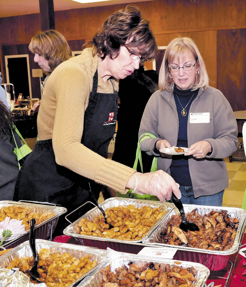 Vendor June Cazeault, left, of Asian Food Solutions, offers a sample of her company's offerings to Laurie Giles, of Nokomis Regional High School, on Tuesday, at the Newport school.