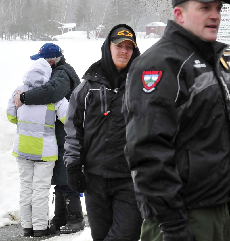 John Spencer Sr. and Jackie Henderson, relatives of two of the missing snowmobilers, hug after becoming emotional as Warden Service Cpl. John MacDonald updates news media on Wednesday about the search for the missing snowmobilers. Spencer is the father of John Spencer Jr. and Henderson is the wife of Glenn Henderson.