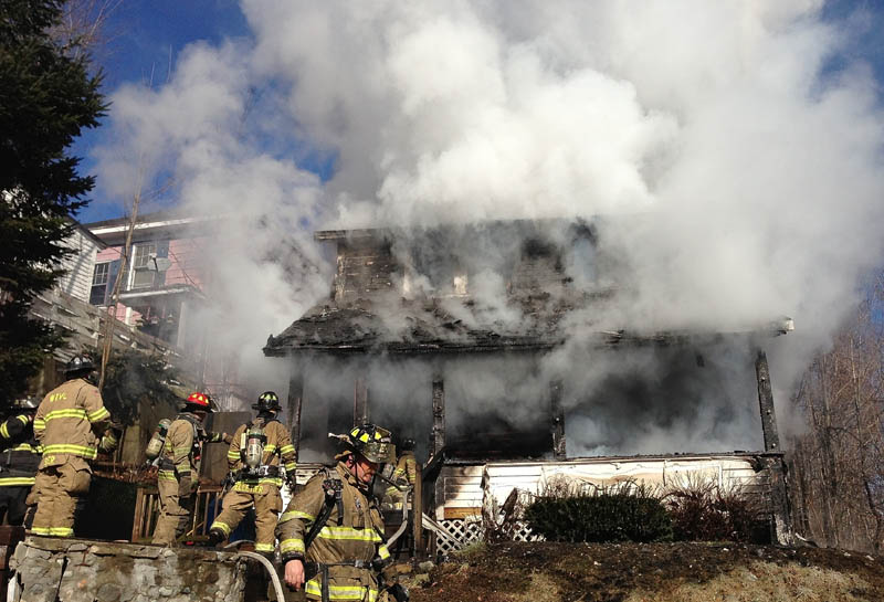 Firefighters battle a house fire on Squire Street in Waterville Thursday morning.