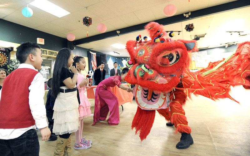 Children watch the dragon dance during the celebration of the lunar new year hosted by the Vietnamese American Association of Maine in Portland on Saturday.
