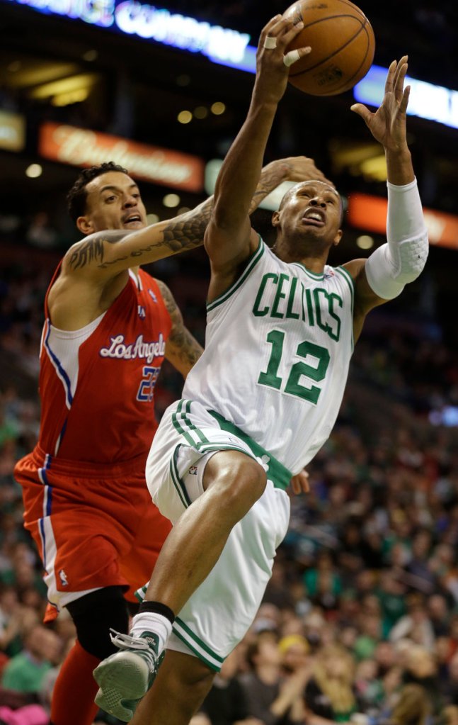Boston guard Leandro Barbosa goes up for a layup while harassed by Los Angeles forward Matt Barnes during Sunday’s game in Boston, won by the Celtics.