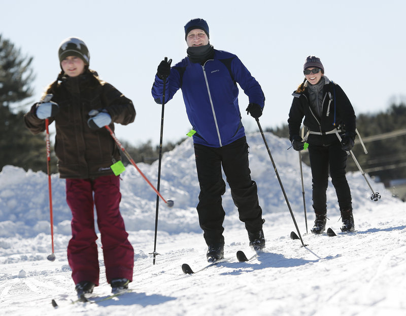 Scott Forrey of Cape Elizabeth skis Sunday with his wife, Patrice, and daughter Haley, 10, at Pineland Farms in New Gloucester, where a variety of winter activities were free for veterans and their families.