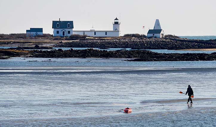 In this file photo, Maine Warden Service Sgt. Tim Spahr searches the water near near Goat Island Lighthouse off Cape Porpoise on Monday, Dec. 24, 2012. The remains of Zachary Wells and Prescott Wright may have washed ashore during the weekend blizzard.