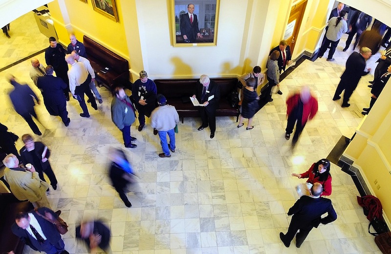 In this file photo, people move through the third floor between the House and Senate chambers at the State House in Augusta. The Maine Legislature's budget-writing committee Wednesday unanimously approved on an emergency spending plan to fix Maine's $153 million budget shortfall.