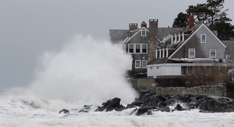 A wave crashes into a house along the shore in Kennebunk on Friday. Waves estimated at 20- to 25 feet caused coastal flooding in some York County towns.