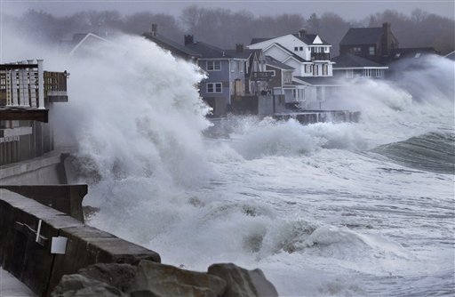 Ocean waves crash over a seawall and into houses along the coast in Scituate, Mass., Thursday, March 7, 2013. A nor'easter is bringing wind-whipped, wet snow to Massachusetts, and coastal flooding is expected in communities still recovering from February's blizzard. (AP Photo/Steven Senne)