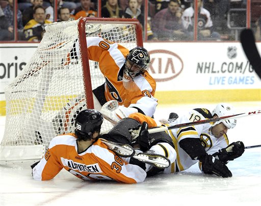 Philadelphia Flyers goalie Ilya Bryzgalov (30), of Russia, watches Oliver Lauridsen (38), of Denmark, and Boston Bruins' Nathan Horton (18) collide in front of the goal in the first period of an NHL hockey game, Saturday, March 30, 2013, in Philadelphia. The Flyers won 3-1. (AP Photo/Michael Perez)