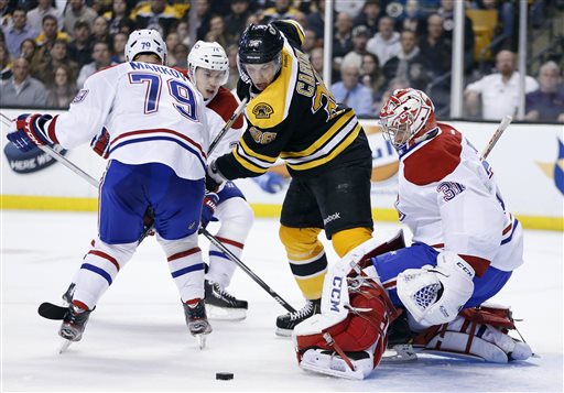Boston Bruins' Jordan Caron (38) tries to control the puck in front of Montreal Canadiens' Carey Price (31) as Canadiens' Andrei Markov (79), of Russia, defends in the second period of an NHL hockey game in Boston, Wednesday, March 27, 2013. (AP Photo/Michael Dwyer)