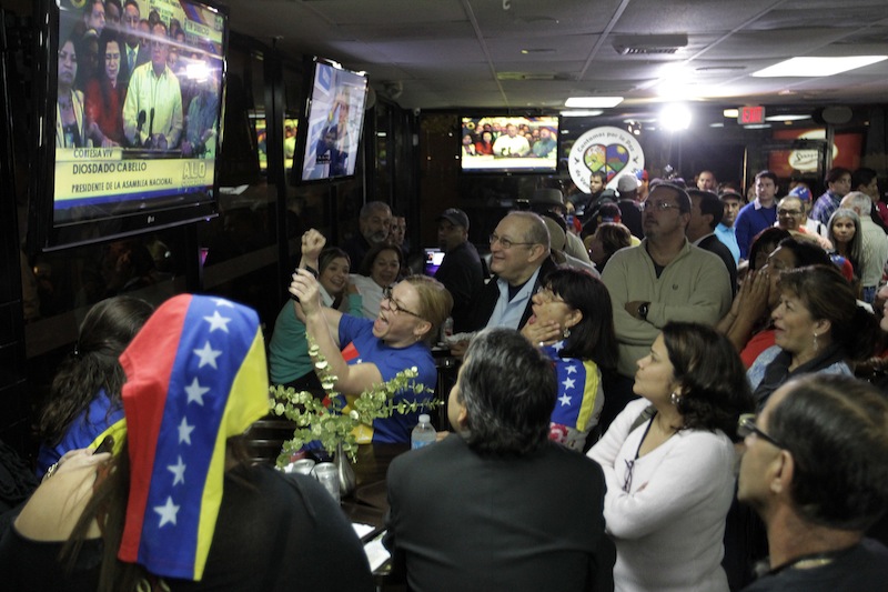 A crowd gathers at the Arepazo 2 restaurant in Doral, Fla., Tuesday, March 5, 2013, after hearing the news of Venezuelan president Hugo Chavez's death. (AP Photo/Luis M. Alvarez)