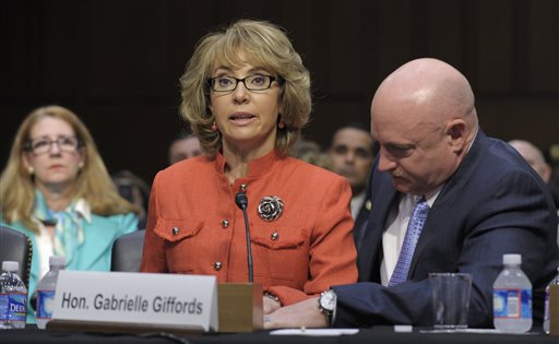 Former Arizona Rep. Gabrielle Giffords is aided by her husband, Mark Kelly, as she speaks before a Senate Judiciary Committee hearing on gun violence in this Jan. 30, 2012, photo.