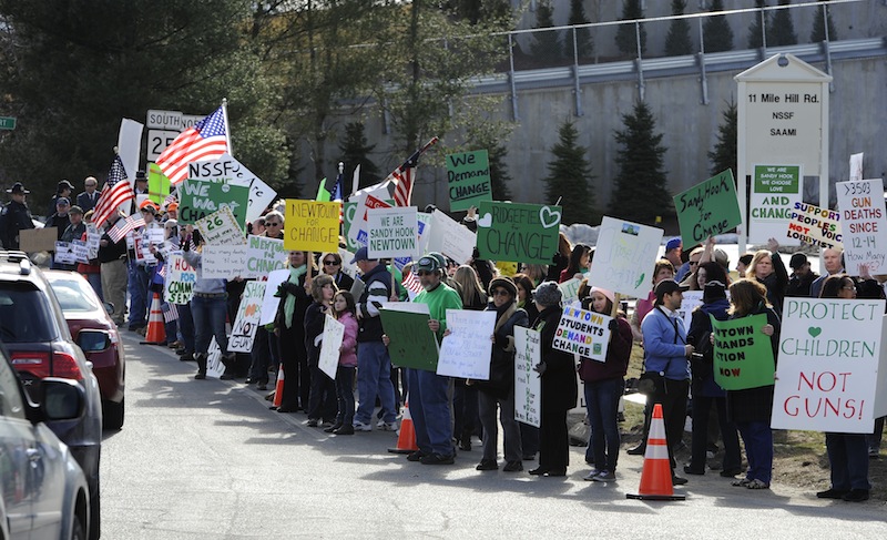Supporters of both sides of the gun debate gather outside the National Shooting Sports Foundation headquarters in Newtown, Conn., Thursday, March 28, 2013. Search warrants released Thursday, March 28, 2013, revealed that an arsenal of weapons including guns, more than a thousand rounds of ammunition, a bayonet and several swords was seized at Adam Lanza's home. Lanza killed his mother, Nancy Lanza in their home before he forced his way into Sandy Hook Elementary School in Newtown, Conn, killing 26 people. (AP Photo/Jessica Hill)