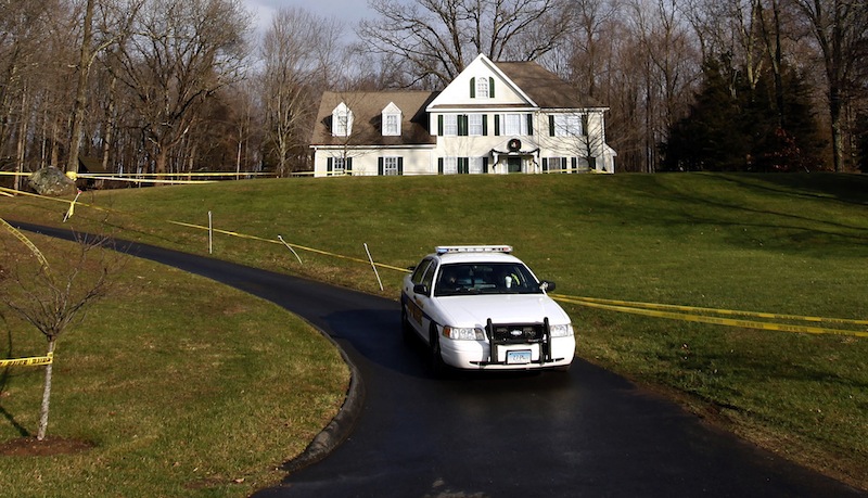 In this Dec. 18, 2012 file photo, a police cruiser sits in the driveway and crime scene tape surrounds the home of Nancy Lanza in Newtown, Conn. Nancy Lanza was killed in the home by her son Adam Lanza before he forced his way into Sandy Hook Elementary School in Newtown, Conn, killing 26 people. Search warrants released Thursday, March 28, 2013, revealed that an arsenal of weapons including guns, more than a thousand rounds of ammunition, a bayonet and several swords was seized in the Lanza home. (AP Photo/Jason DeCrow)