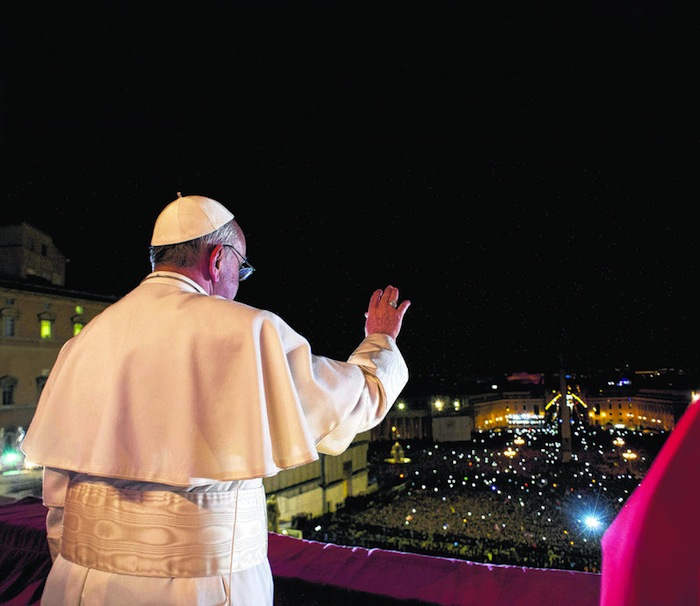 Pope Francis waves to the crowd from the central balcony of St. Peter's Basilica at the Vatican in a photograph released by Osservatore Romano at the Vatican, March 13, 2013. (AP Photo/L'Osservatore Romano)