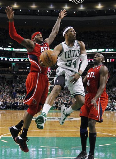 Boston Celtics' Paul Pierce (34) passes off between Atlanta Hawks' Josh Smith, left, and Anthony Tolliver (4) during the second half of NBA basketball game in Boston, Friday, March 8, 2013. The Celtics won 107-102 in overtime. (AP Photo/Michael Dwyer)