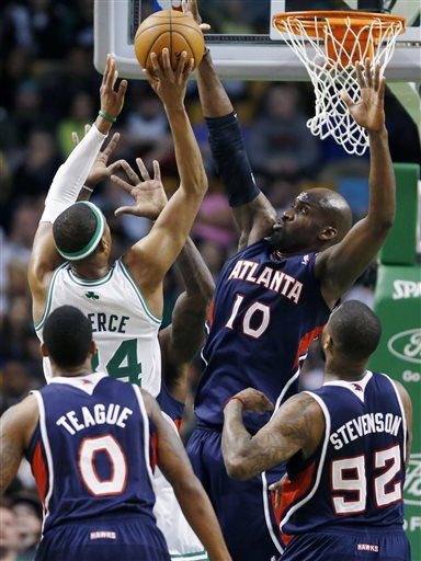 Atlanta Hawks' Johan Petro (10) blocks a shot by Boston Celtics' Paul Pierce (34) during the first quarter of an NBA basketball game in Boston, Friday, March 29, 2013. (AP Photo/Michael Dwyer)