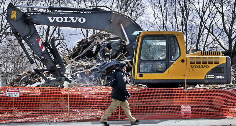 An excavator sits next to the debris from an apartment building that was razed over the weekend at 55 Sewall St. in in Augusta Monday. The four-story building was destroyed by fire Jan. 10.