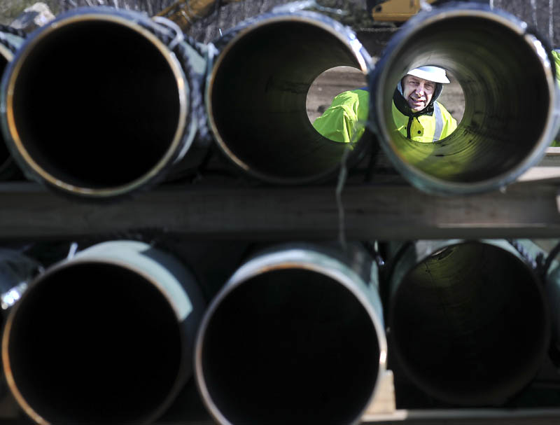 Rick Bellemare inspects a steel pipe delivered to the Windsor laydown yard of Maine Natural Gas on Monday. The firm, competing to deliver gas to Kennebec County, expects to start installing pipes in Windsor to connect a line to Augusta. Bellemare works for Enterprise Trenchless Technologies of Lisbon Falls.