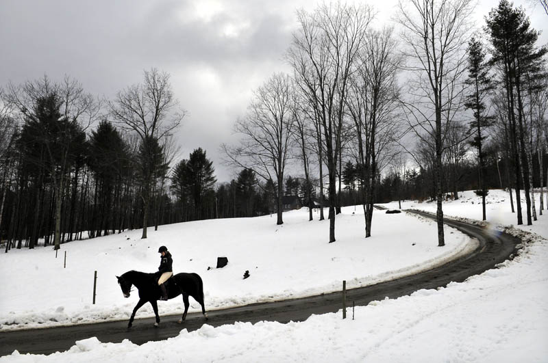 Kelsey Stinneford, of Wayne, leads her horse beneath overcast skies Tuesday, down a lane in Wayne while riding back to the Taylor Farm in Fayette, where she stables the steed. A competitive rider on the dressage team at Post University in Connecticut, Stinneford said the wet conditions do not deter her from riding. "This is how I choose to spend my spring break," she said.