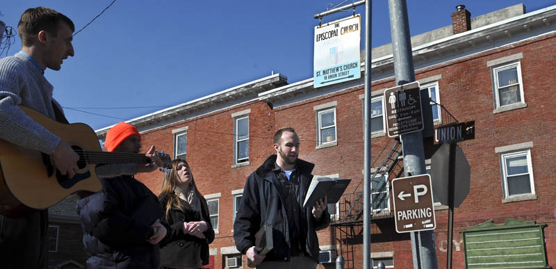 Mark McLain, left, plays the guitar while Stephen Arsenault, Marsha Mann and her husband Jacob sing hymns Sunday on Water Street in Hallowell. The quartet held a street meeting to spread the message of their Pentecostal faith. The members of New Light Fellowship Church in Augusta said they plan to sing and pray outside more often as the weather improves.