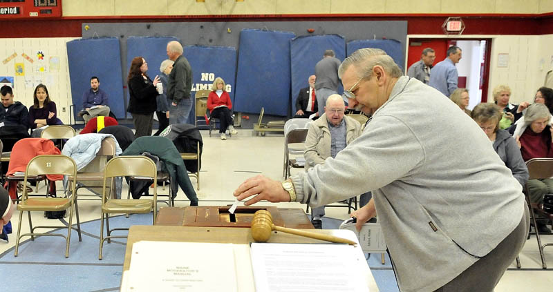 Nelson Harding, 69, places his vote for Article 3 in to the ballot box during the annual Town Meeting at the Albion Elementary School Saturday.