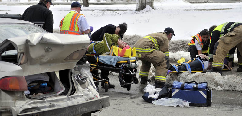 Rescue workers from the Waterville fire department, Delta Ambulance and Waterville police department tend to people injured in an accident on Upper Main Street Friday afternoon. Two adults and two children were taken to MaineGeneral Medical Center's Thayer Campus for neck and back pain and minor injuries.