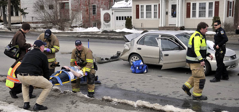 Rescue workers from the Waterville fire department, Delta Ambulance and Waterville police department tend to people injured in an accident on Upper Main Street Friday afternoon.