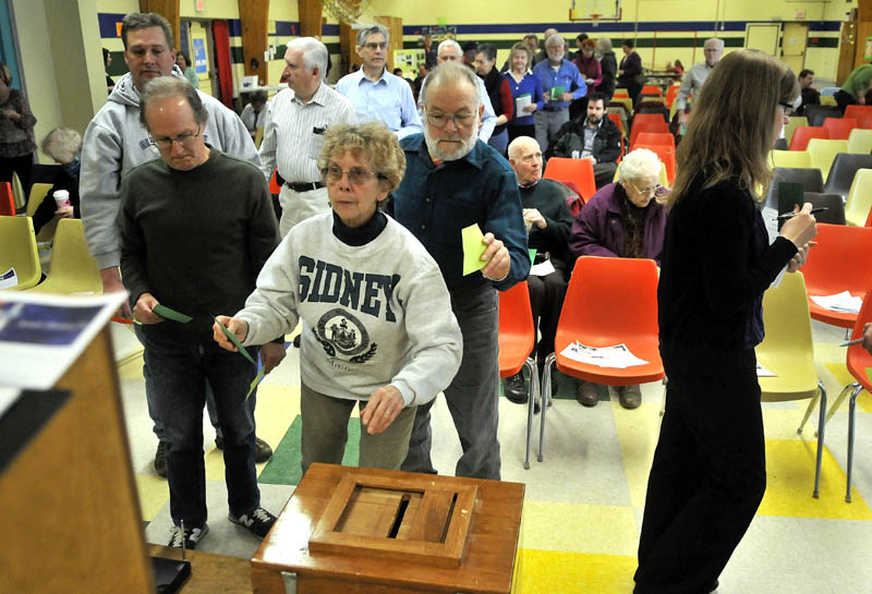 Nancy Robbins, of Sidney, casts her written ballot for a vote on budget committee members during the annual town meeting at the James H. Bean School Saturday.