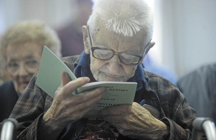 Cornville's oldest resident, Laurence Amazeen, 98, skims through the town's annual report before the start of the Town Meeting at Town Hall Saturday morning.