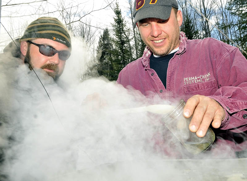 Bruce Marshall, 32, right, pours a small sample of maple syrup as Nate Smart, left, watches while sugaring in Oakland Saturday. Smart and Marshall enjoy sugaring this time of year. "It gets you out of the house. This time of year you really can't do much. Snow is gone for snowmobiling and not dry enough for riding the ATVs." Smart said. "Plus you have something to show for a day outdoors with some fresh maple syrup." The two have been friends since grade school and were sugaring on their property in Oakland.