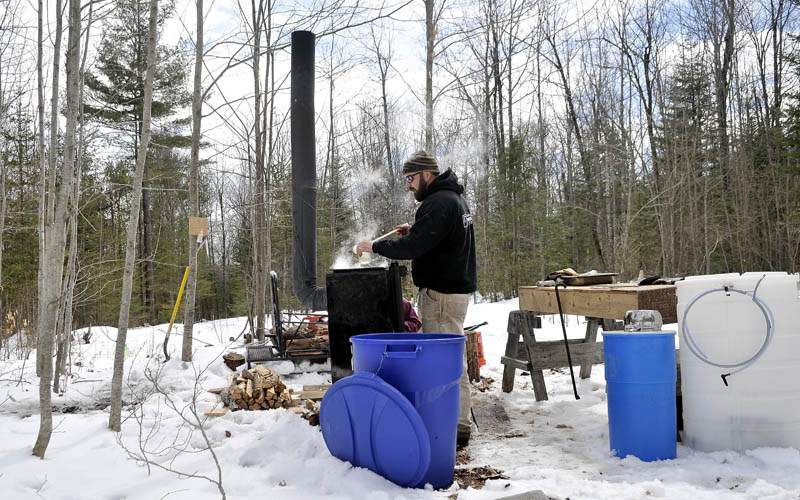 Nate Smart pours a sample of syrup at his friends' Axtell Road residence in Oakland Saturday. Smart and his friend, Bruce Marshall, planned to spend the weekend harvesting maple syrup.
