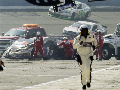 Rescue workers tend to the wreckage of Denny Hamlin (11) after he collided with Joey Logano on the final lap of the NASCAR Sprint Cup race Sunday in Fontana, Calif. NASCAR is not penalizing Tony Stewart for scuffling with Joey Logano on pit road at California, and viewed the crash between Logano and Denny Hamlin as a racing incident. Auto Club 400