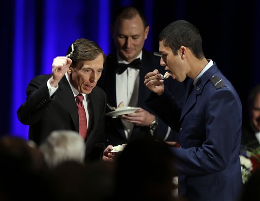 David H. Petraeus, former army general and head of the Central Intelligence Agency, tastes a ceremonial cake presented to him by Hector Sandoval, a member of the USC ROTC program, at the annual dinner for veterans and ROTC students at the University of Southern California, in Los Angeles Tuesday.