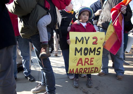 Gabriela Fore, 6, of Upper Darby Pa., holds a sign with her moms in front of the Supreme Court in Washington on Wednesday as the court heard arguments on the constitutionality of the Defense of Marriage Act.