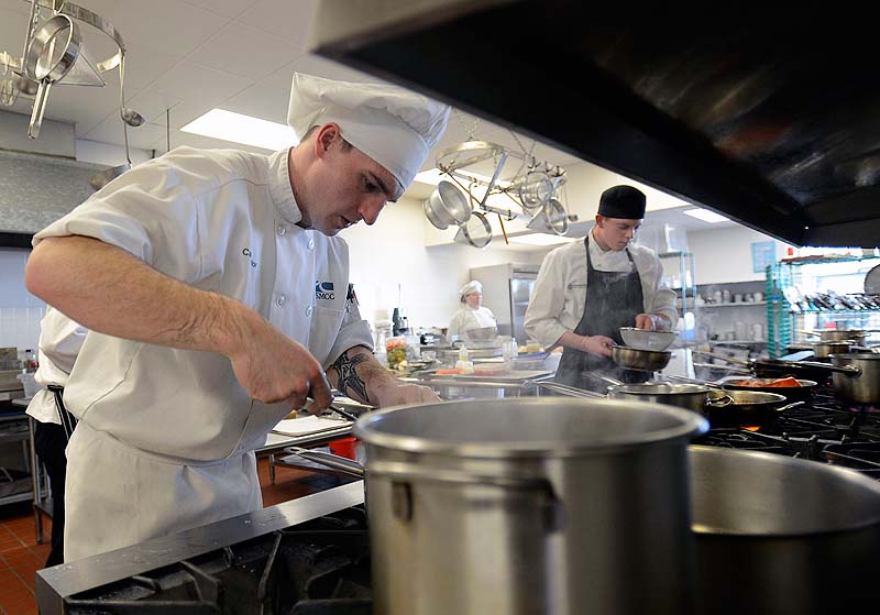 Casey Taylor 19, of Kenenbunk, a student at SMMC, prepares a meal during the Chaine des Rotisseurs' Jeunes Chefs Rotisseur Competition at Southern Maine Community College on Sunday. Competing to the right is Andrew Coen 22, of Boston.