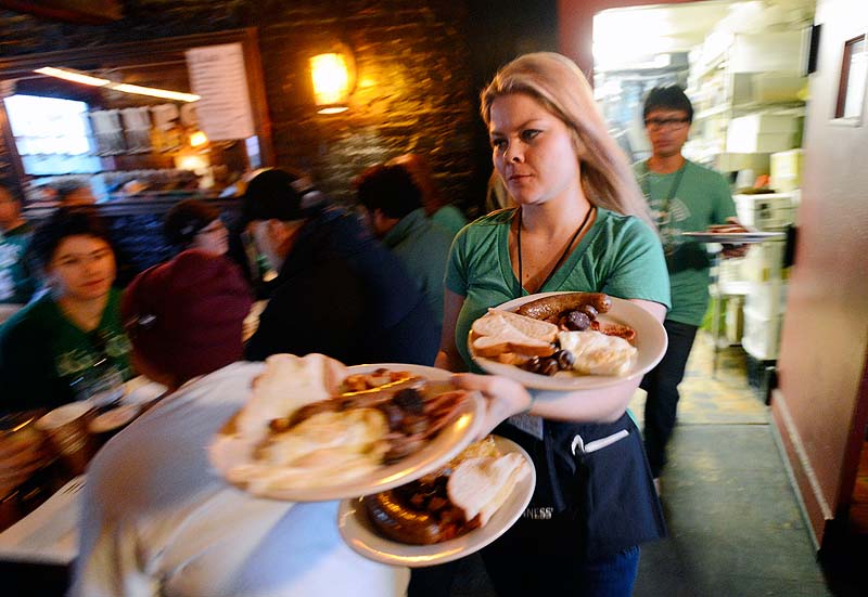 Katya Dolloff, a server at Brian Boru in Portland, delivers Irish breakfasts to customers during St. Patrick’s Day celebrations Sunday. Offerings included rashers, black and white pudding and bangers and mash.