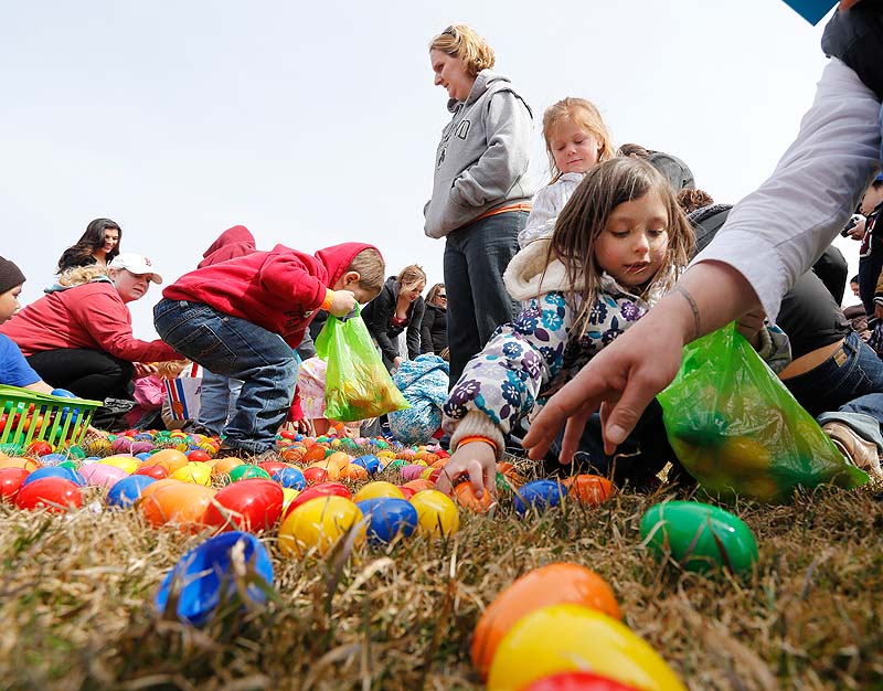 Next Level Church hosts an Easter egg drop at Payson Park in Portland on Sunday. Courtney Lane-Hebert of Lisbon watches as her son, Mason Hebert, 3, collects eggs. At right, Morgan McLaskey, 6, of Westbrook fills her bag.